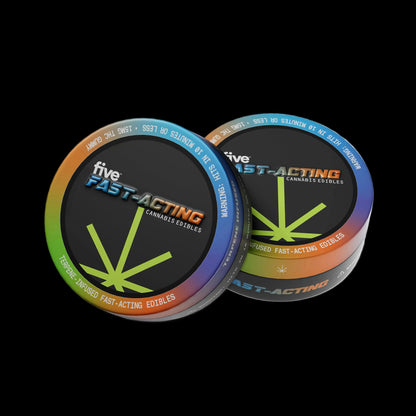 Angled view of Quick Hits tin showing rainbow rim, 'five FAST-ACTING' cannabis edibles logo and green stylized leaf on black background
