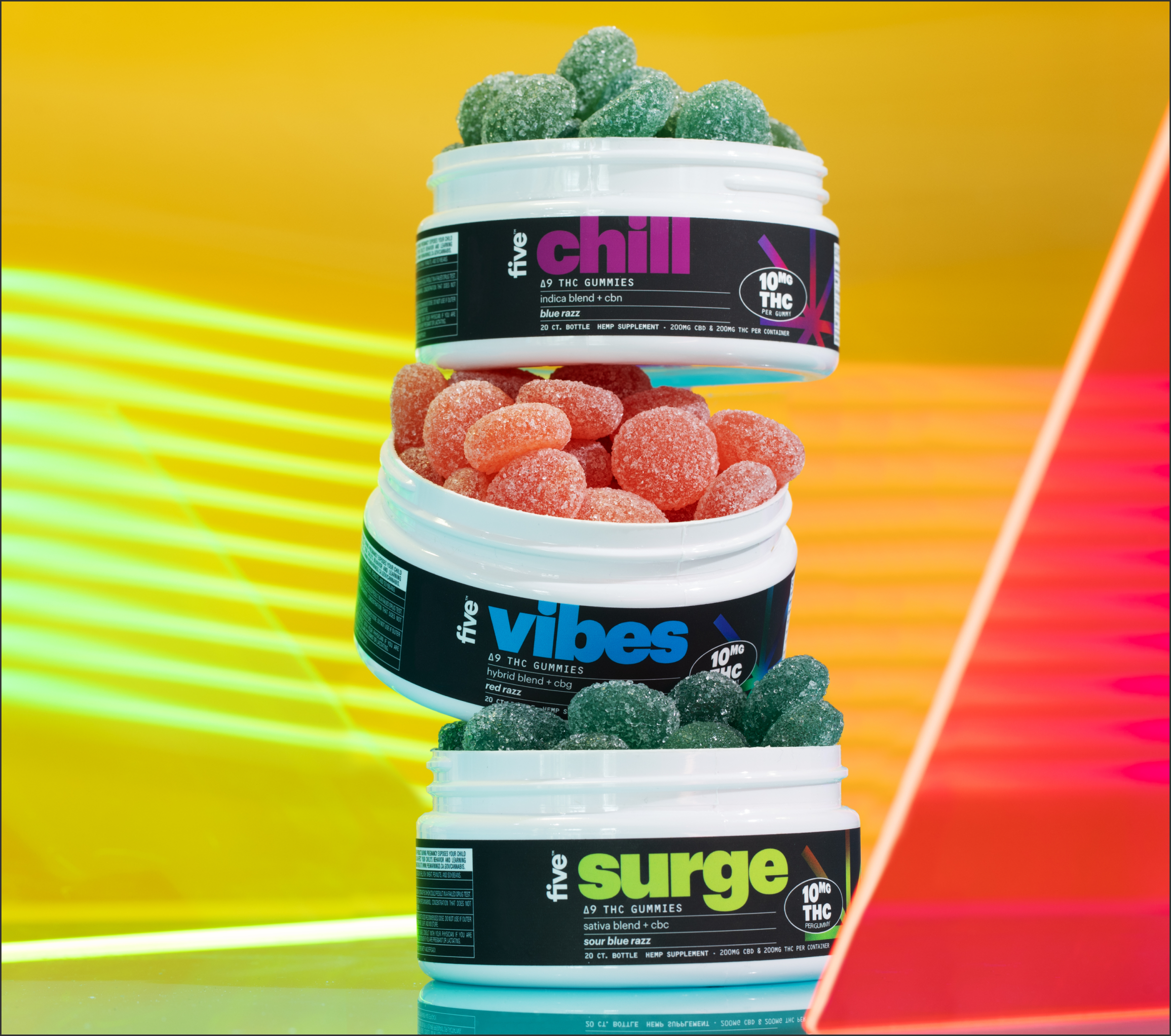 Three stacked white containers of THC gummies labeled 'five chill', 'five vibes', and 'five surge', each with different colored gummies and text indicating 10 MG THC per gummy and flavor names like 'blue razz', 'red razz', and 'sour blue razz'.
