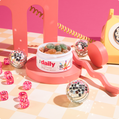 Daily Buzz THC Gummies on a table with disco lights and a retro phone