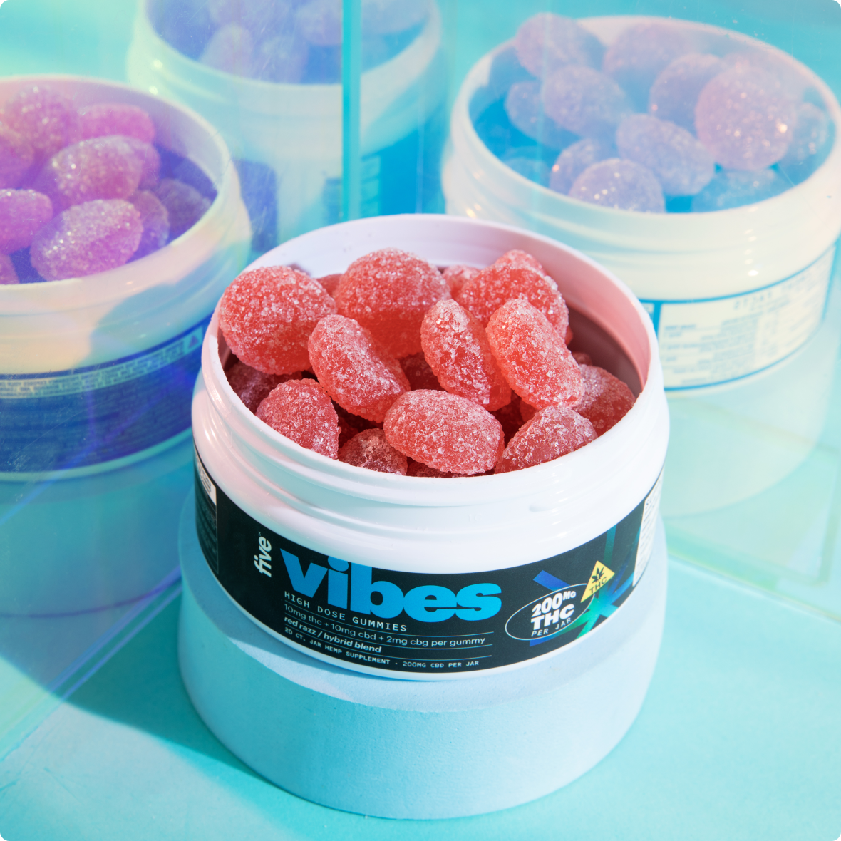 White jar labeled 'five vibes', 'HIGH DOSE GUMMIES', and '200MG THC PER JAR' filled with sugar-coated red gummy candies
